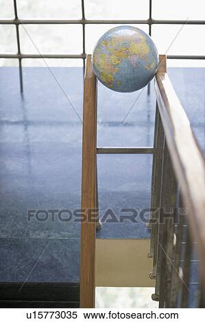 Stock Photography - High angle view of a globe between the railings of a staircase. Fotosearch