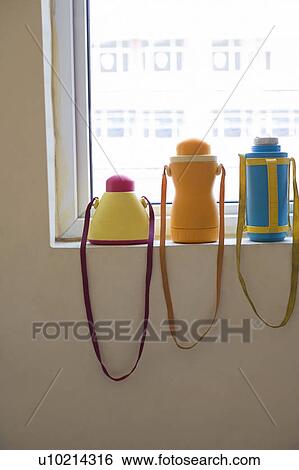 Three water bottles on a window sill View Large Photo Image Stock Photograph - Three water bottles on a window sill. Fotosearch