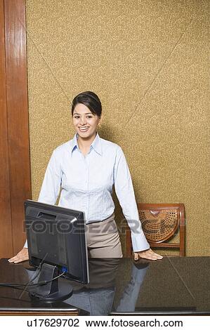 Businesswoman standing in an office and smiling View Large Photo Image Stock Image - Businesswoman standing in an office and smiling. Fotosearch