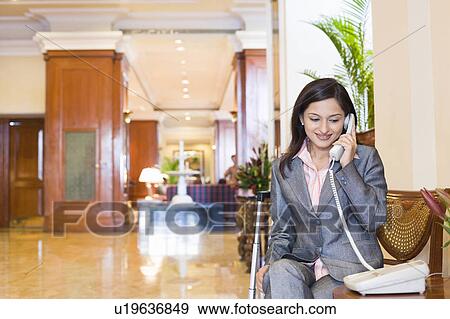 Stock Photo - Businesswoman talking on the telephone and smiling. Fotosearch