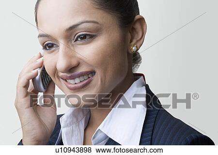Close-up of a businesswoman talking on a mobile phone and smiling View Large Photo Image Stock Photo - Close-up of a businesswoman talking on a mobile phone and smiling. Fotosearch