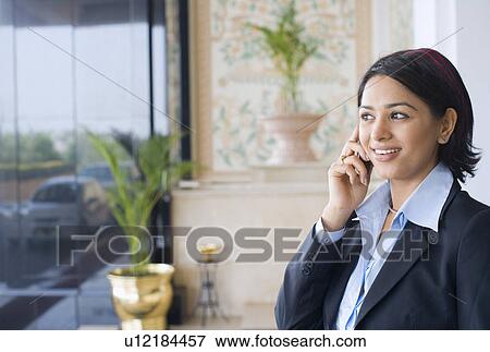Close-up of a businesswoman talking on a mobile phone and smiling View Large Photo Image Stock Photo - Close-up of a businesswoman talking on a mobile phone and smiling. Fotosearch