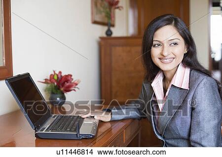 Close-up of a businesswoman using a laptop and smiling View Large Photo Image Picture - Close-up of a businesswoman using a laptop and smiling. Fotosearch
