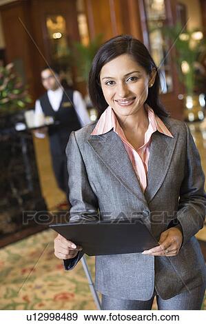 Stock Photo - Portrait of a businesswoman holding a file and smiling. Fotosearch