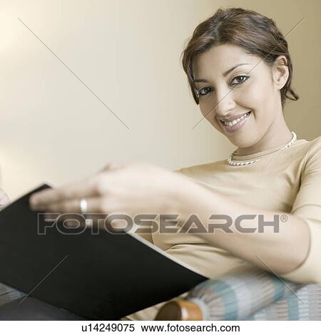 Portrait of a businesswoman holding a file and smiling View Large Photo Image Stock Photography - Portrait of a businesswoman holding a file and smiling. Fotosearch