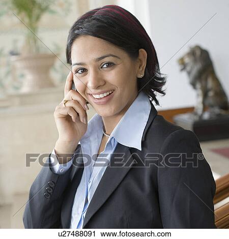 Portrait of a businesswoman talking on a mobile phone and smiling View Large Photo Image Stock Image - Portrait of a businesswoman talking on a mobile phone and smiling. Fotosearch