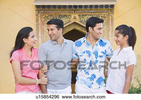 Stock Photograph - Close-up of a young couple and a mid adult couple smiling together. Fotosearch