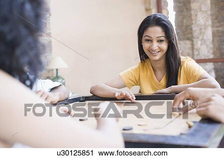 Close-up of a young woman playing carom View Large Photo Image Stock Image - Close-up of a young woman playing carom. Fotosearch