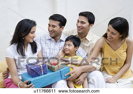 Stock Image - Close-up of two couples sitting with a boy and smiling. Fotosearch