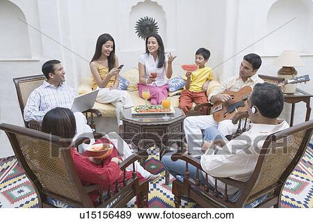 Stock Photo - Family sitting in a room and smiling. Fotosearch