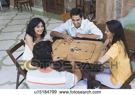 Four people playing carom View Large Photo Image Stock Photo - Four people playing carom. Fotosearch