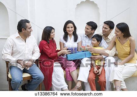 Group of people sitting together with gifts and smiling View Large Photo Image Picture - Group of people sitting together with gifts and smiling. Fotosearch