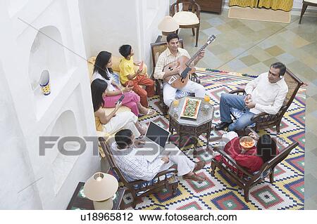 High angle view of a family sitting in a room View Large Photo Image Stock Image - High angle view of a family sitting in a room. Fotosearch