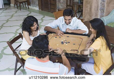 High angle view of two young men and two young women playing carom View Large Photo Image Stock Photograph - High angle view of two young men and two young women playing carom. Fotosearch