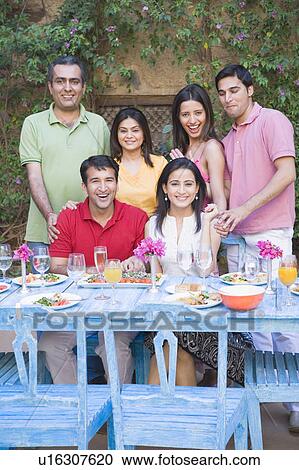 Portrait of a group of people at a dining table and smiling View Large Photo Image Stock Image - Portrait of a group of people at a dining table and smiling. Fotosearch