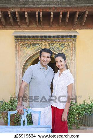 Portrait of a mid adult man standing with a young woman and smiling View Large Photo Image Picture - Portrait of a mid adult man standing with a young woman and smiling. Fotosearch