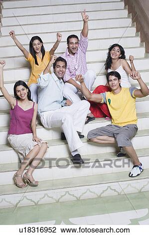 Stock Image - Portrait of three young couples sitting on steps and smiling. Fotosearch