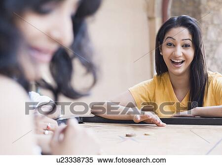 Two young women playing carom View Large Photo Image Stock Photography - Two young women playing carom. Fotosearch