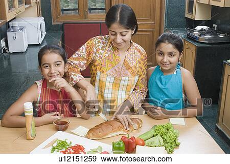 Close-up of a mid adult woman making sandwiches with her daughters View Large Photo Image Stock Photo - Close-up of a mid adult woman making sandwiches with her daughters. Fotosearch