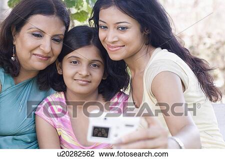 Close-up of a three generation family taking a photograph of themselves with a digital camera View Large Photo Image Stock Image - Close-up of a three generation family taking a photograph of themselves with a digital camera. Fotosearch