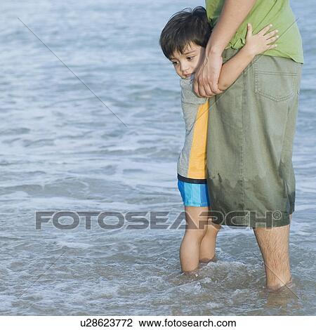Mid section view of a mid adult man standing with his son on the beach View Large Photo Image Stock Image - Mid section view of a mid adult man standing with his son on the beach . Fotosearch