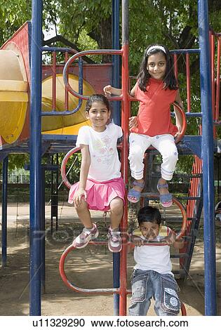Portrait of a boy playing with two girls on the jungle gym View Large Photo Image Stock Image - Portrait of a boy playing with two girls on the jungle gym. Fotosearch