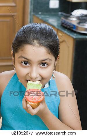 Portrait of a girl eating a sandwich View Large Photo Image Stock Photo - Portrait of a girl eating a sandwich. Fotosearch