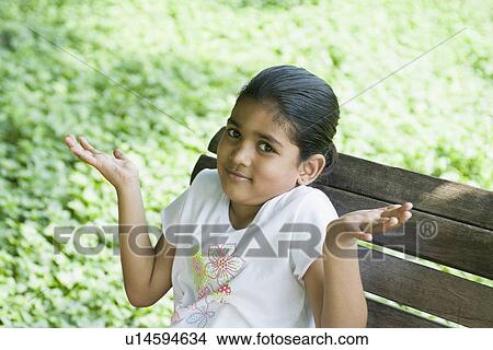 Portrait of a girl shrugging and sitting on a branch View Large Photo Image Picture - Portrait of a girl shrugging and sitting on a branch. Fotosearch