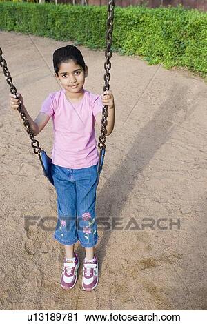 Portrait of a girl sitting on a swing View Large Photo Image Stock Image - Portrait of a girl sitting on a swing. Fotosearch