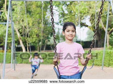 Stock Photography - Portrait of a girl sitting on a swing. Fotosearch