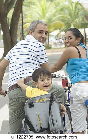 Portrait of a mid adult couple sitting on bicycles with their son View Large Photo Image Stock Photography - Portrait of a mid adult couple sitting on bicycles with their son . Fotosearch