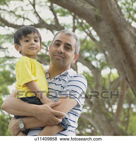 Portrait of a mid adult man carrying his son View Large Photo Image Stock Photo - Portrait of a mid adult man carrying his son . Fotosearch