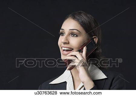 Close-up of a businesswoman talking on a mobile phone and smiling View Large Photo Image Stock Photo - Close-up of a businesswoman talking on a mobile phone and smiling. Fotosearch