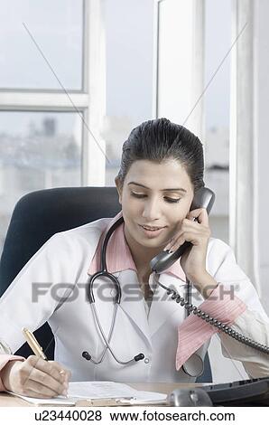 Close-up of a female doctor talking on the telephone View Large Photo Image Stock Photo - Close-up of a female doctor talking on the telephone. Fotosearch