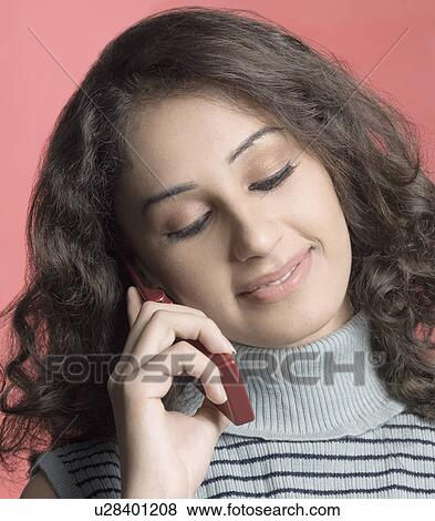 Stock Photo - Close-up of a young woman talking on a mobile phone. Fotosearch