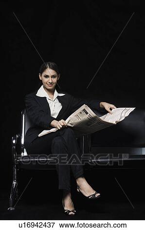 Portrait of a businesswoman sitting on a bench and holding a newspaper View Large Photo Image Stock Photo - Portrait of a businesswoman sitting on a bench and holding a newspaper. Fotosearch
