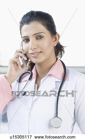 Stock Photo - Portrait of a female doctor talking on a mobile phone. Fotosearch