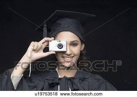 Stock Photo - Portrait of a young female graduate taking a picture. Fotosearch