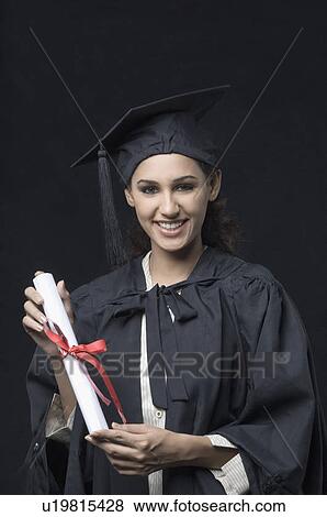 Stock Photo - Portrait of a young female graduate holding a diploma. Fotosearch