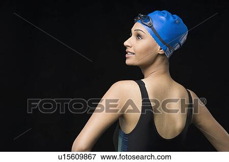 Rear view of a young woman wearing swimwear and looking away View Large Photo Image Stock Photo - Rear view of a young woman wearing swimwear and looking away. Fotosearch