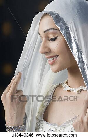 Close-up of a young woman in lehenga choli and smiling View Large Photo Image Stock Photograph - Close-up of a young woman in lehenga choli and smiling. Fotosearch