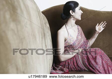 Stock Photo - Close-up of a young woman sitting on a couch. Fotosearch