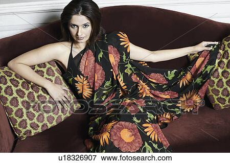 High angle view of a young woman sitting on a couch View Large Photo Image Stock Photo - High angle view of a young woman sitting on a couch. Fotosearch