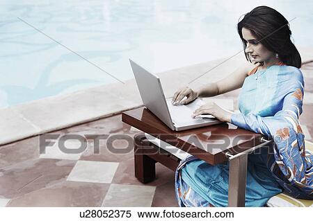 High angle view of a young woman using a laptop View Large Photo Image Stock Photography - High angle view of a young woman using a laptop. Fotosearch