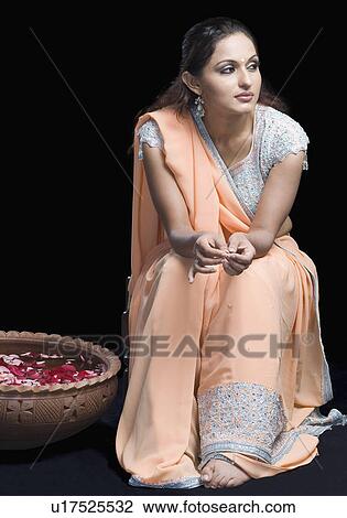 Mid adult woman in lehenga choli and sitting on a stool with a bowl of petals View Large Photo Image Stock Image - Mid adult woman in lehenga choli and sitting on a stool with a bowl of petals. Fotosearch