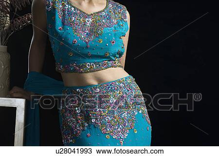 Mid section view of a mid adult woman standing in lehenga choli View Large Photo Image Stock Image - Mid section view of a mid adult woman standing in lehenga choli. Fotosearch
