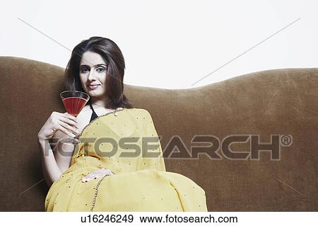Portrait of a young woman holding a martini glass View Large Photo Image Stock Photo - Portrait of a young woman holding a martini glass. Fotosearch