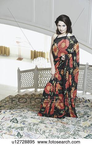 Portrait of a young woman standing on a staircase View Large Photo Image Stock Photography - Portrait of a young woman standing on a staircase. Fotosearch