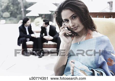 Portrait of a young woman talking on a mobile phone View Large Photo Image Stock Image - Portrait of a young woman talking on a mobile phone. Fotosearch