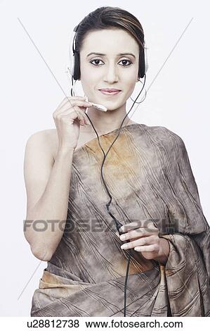 Stock Photo - Portrait of a young woman wearing a headset. Fotosearch